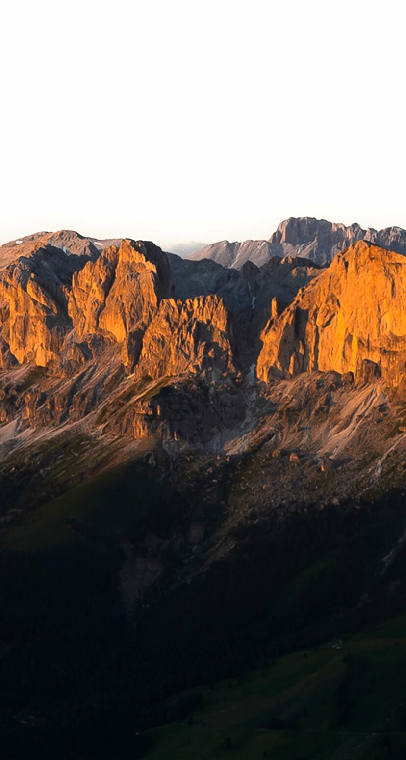 Red illuminated mountain range Rosengarten - Dolomites | © Valentin Pardeller