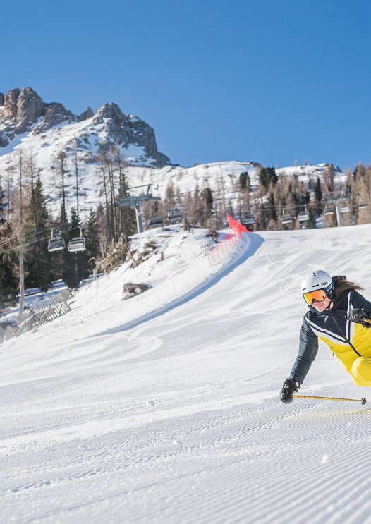 Skifahrer Abfahrt Pra di Tori Piste im Hintergrund Latemar | © Carezza Dolomites/Harald Wisthaler