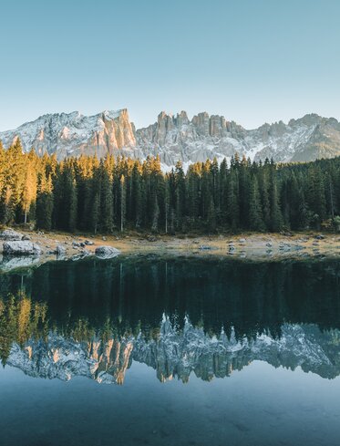 Lake Carezza colourful water - first snow on Latemar | © Carezza Dolomites/StorytellerLabs