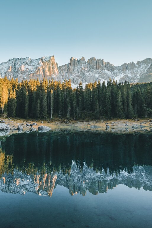 Lake Carezza colourful water - first snow on Latemar | © Carezza Dolomites/StorytellerLabs